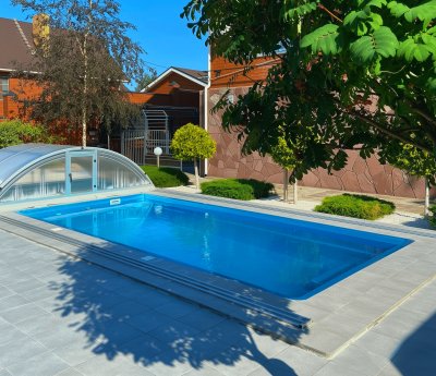 Прямоугольный бассейн с сдвижным поликарбонатным павильоном и белым гравием вокруг